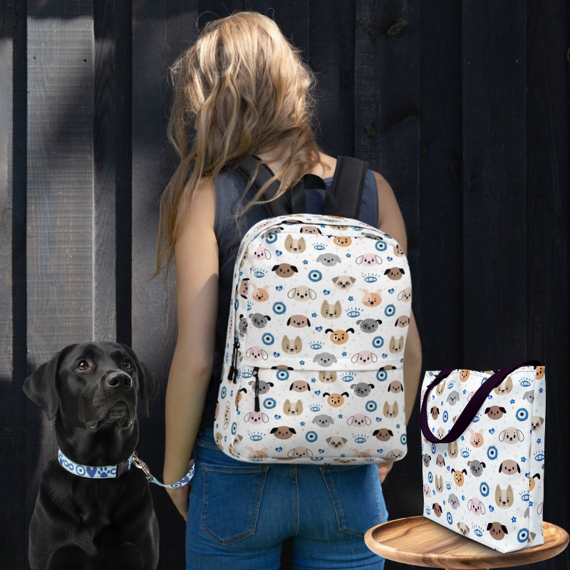 Woman carrying evil eye backpack, black labrador with evil eye collar, and evil eye tote bag